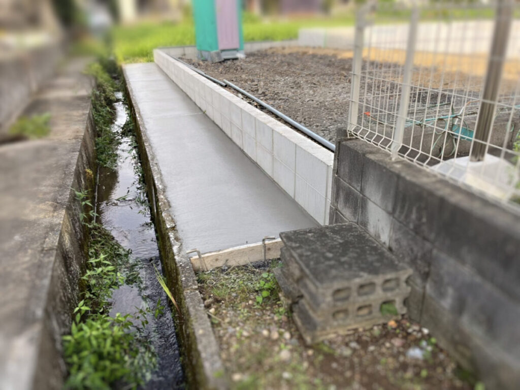 重機を使用した水路のコンクリート打設作業中の様子