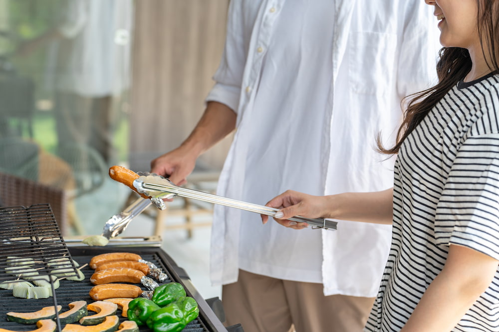 ウッドデッキでBBQを楽しむファミリー。デッキのメンテナンスで安全な屋外空間に