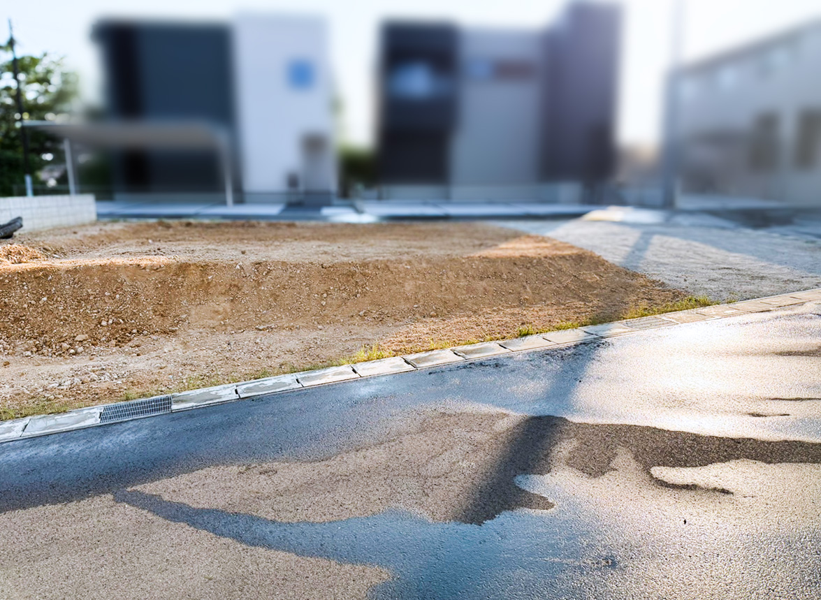 地鎮祭用の造成工事を擁壁側から撮影。整地が完了し、中央に地鎮祭用の盛砂が台形状に設置されている