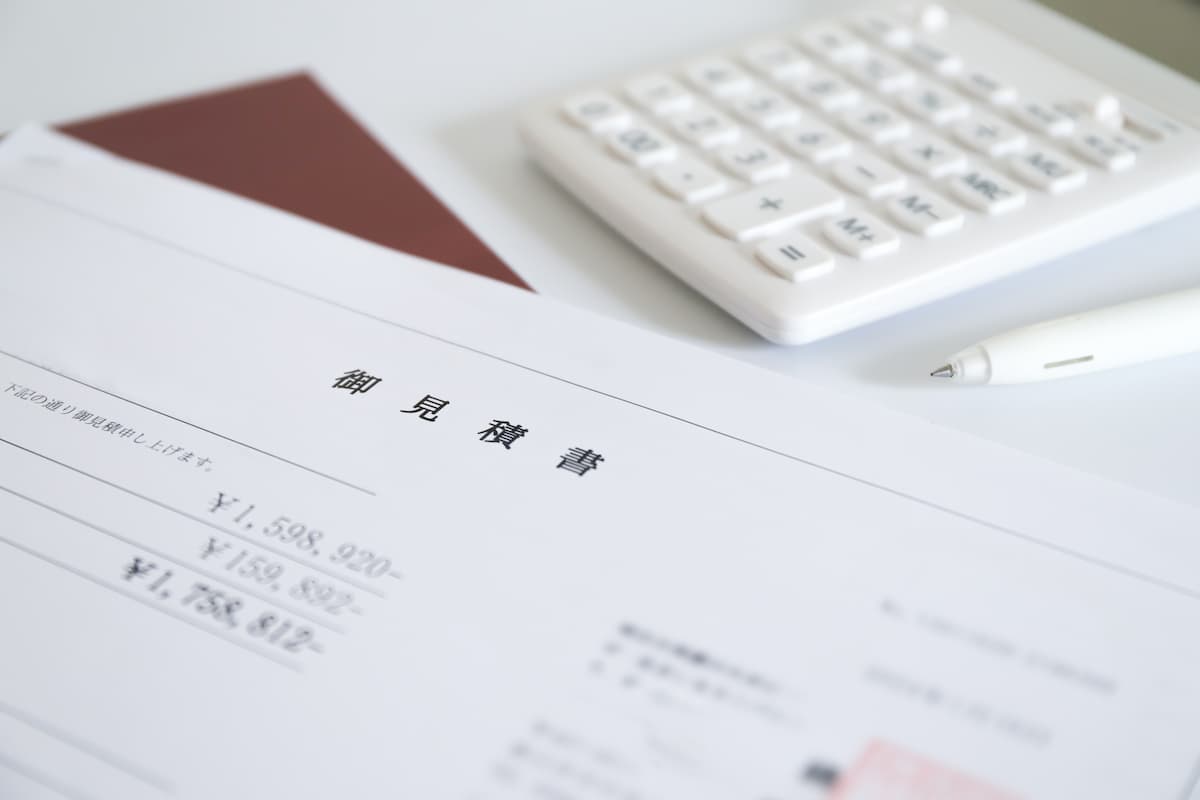 土間コンクリートの見積書を電卓で確認する様子