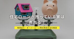 住宅ローンが残っている家は売れる？残債あり・オーバーローン時の売却方法を解説する記事のアイキャッチ。家の模型と貯金箱を天秤にかけたイメージ